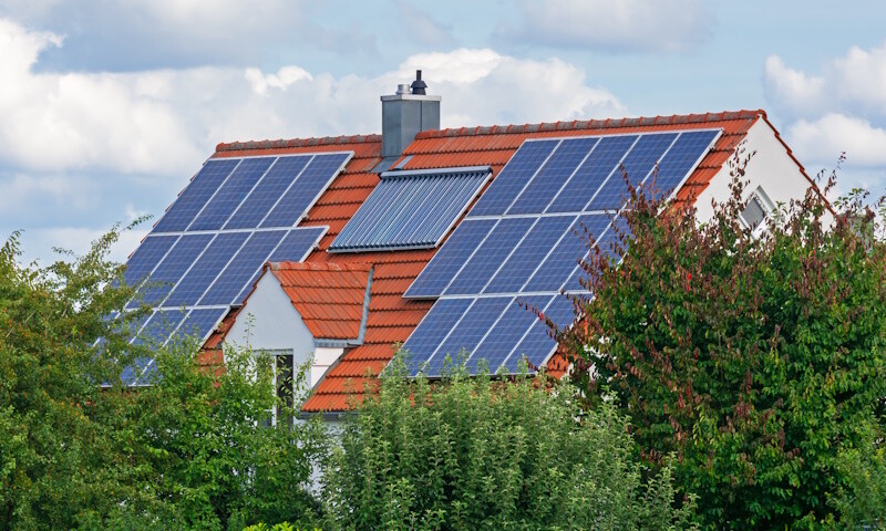 Dach eines Einfamilienhauses mit PV-Anlage und Solarthermie-Anlage