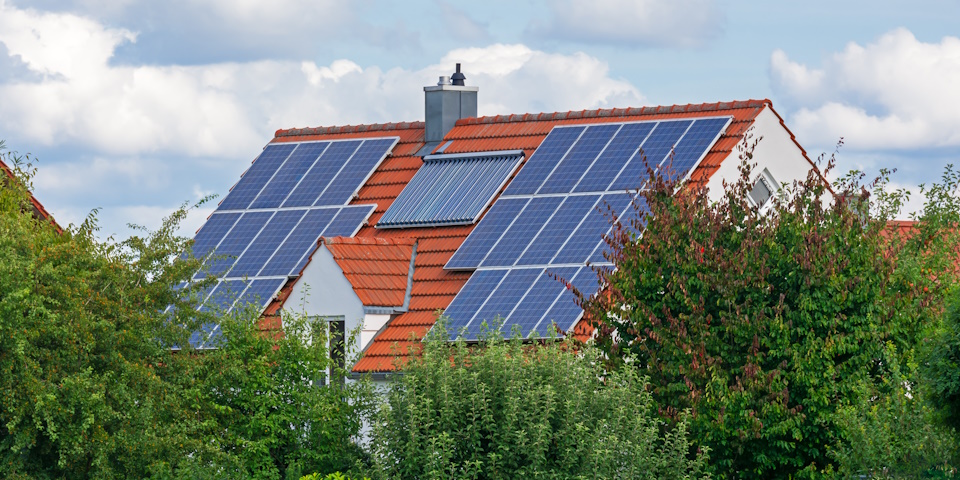Dach eines Einfamilienhauses mit PV-Anlage und Solarthermie-Anlage